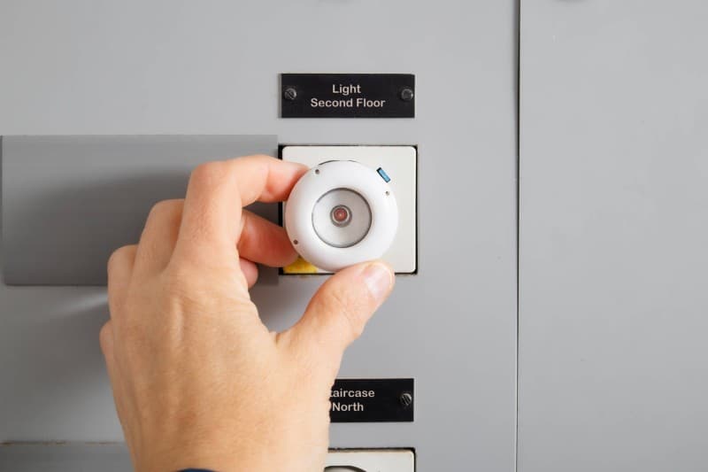 Hauswart justiert die Lichtsteuerung im Treppenhaus einer Liegenschaft